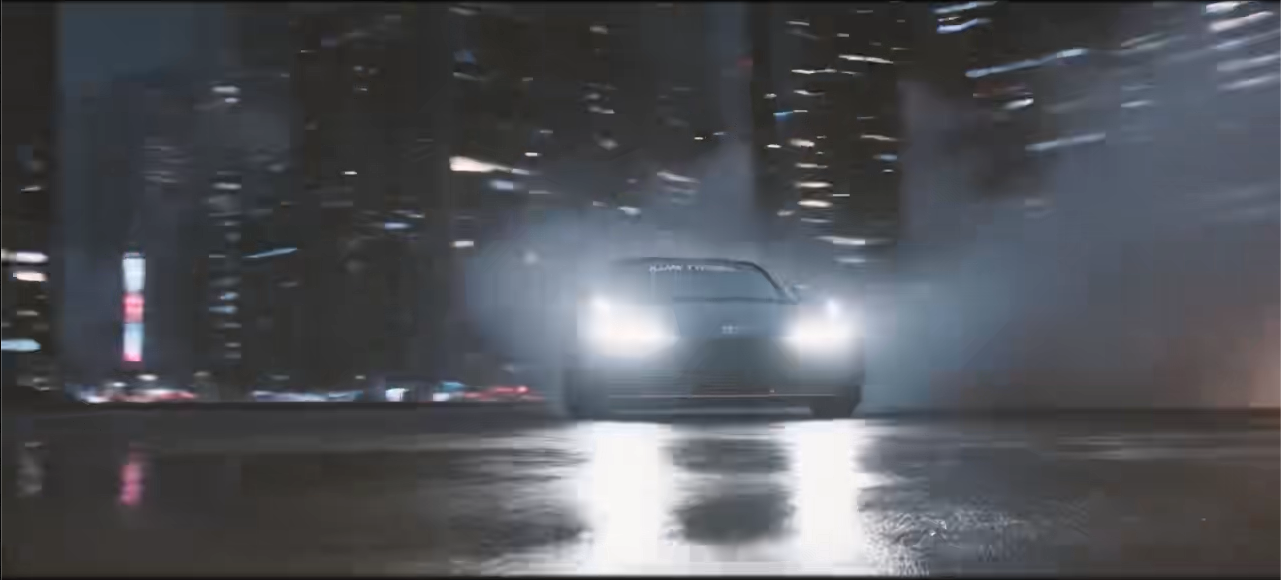 Model car headlights emerging through mist on a wet city road