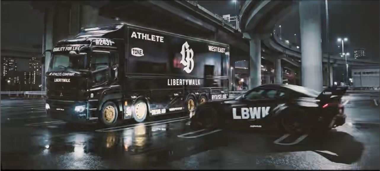 LBWK model car driving beside a branded truck at night